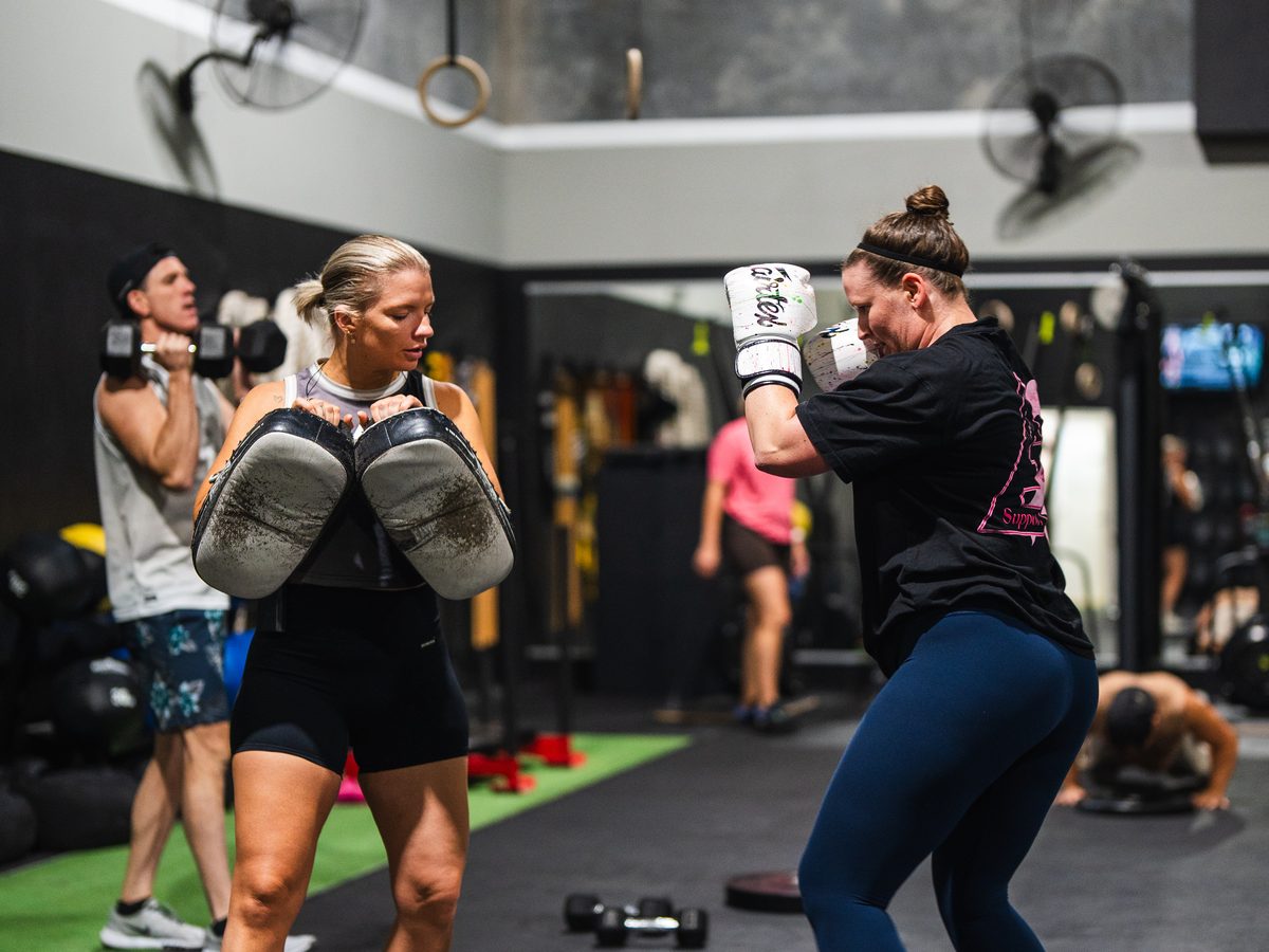 Member training Muay Thai pads in an Empower class